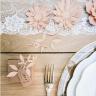 Blomstergrene i lyserød pynter på spisebord